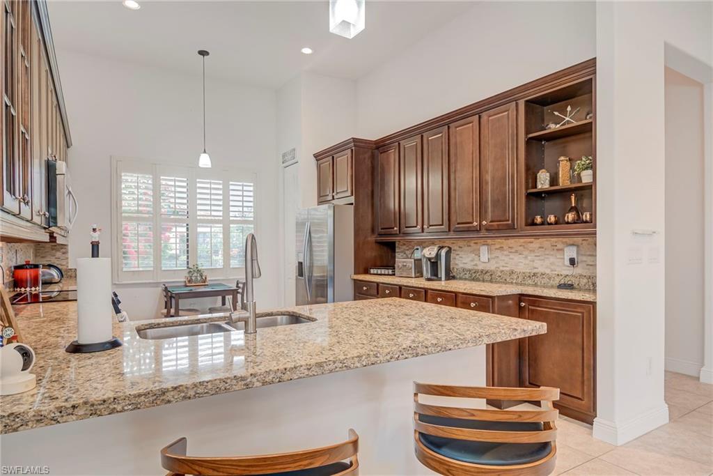 5239 Ferrari Avenue Ave Maria, FL 34142 - Photo 8 of 30 a kitchen with granite countertop kitchen island stainless steel appliances a sink and a counter top space