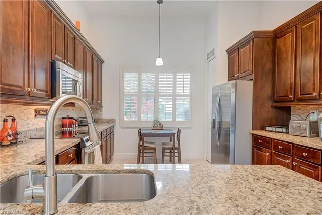 a kitchen with stainless steel appliances granite countertop a refrigerator and a sink
