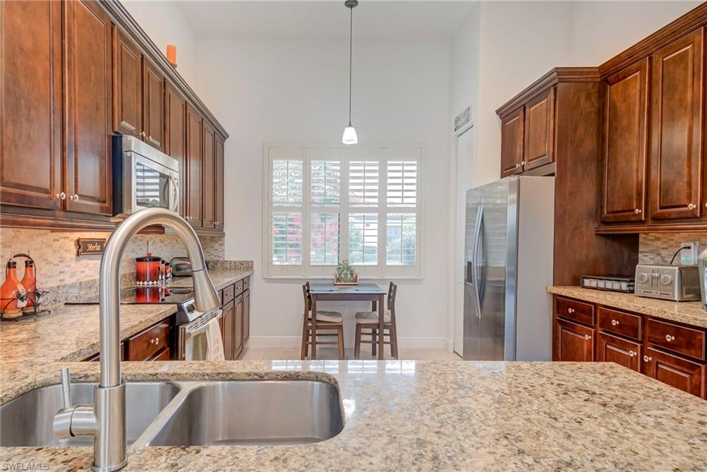 5239 Ferrari Avenue Ave Maria, FL 34142 - Photo 10 of 30 a kitchen with stainless steel appliances granite countertop a refrigerator and a sink