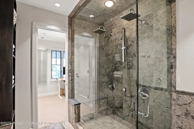 a bathroom with a shower and a glass door