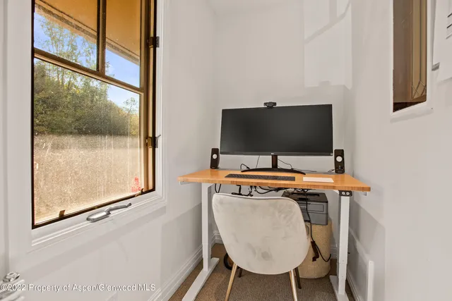 a view of a workspace with furniture and a flat screen tv