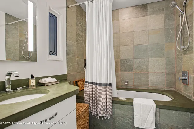 a bathroom with a granite countertop sink a toilet and shower