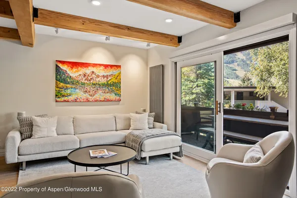 a living room with furniture a rug and a large window
