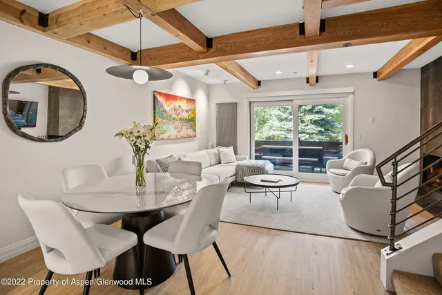 a living room with furniture a chandelier and a large window