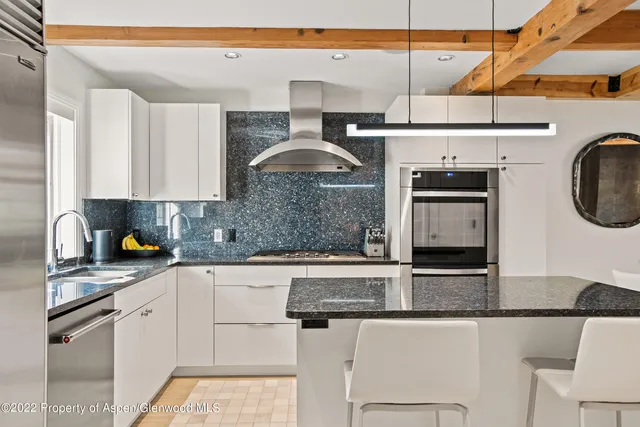a kitchen with stainless steel appliances granite countertop a sink a stove and cabinets
