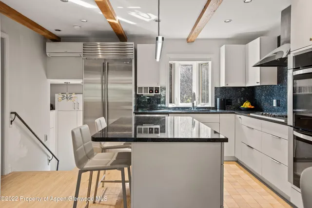 a kitchen with stainless steel appliances granite countertop a sink and a refrigerator