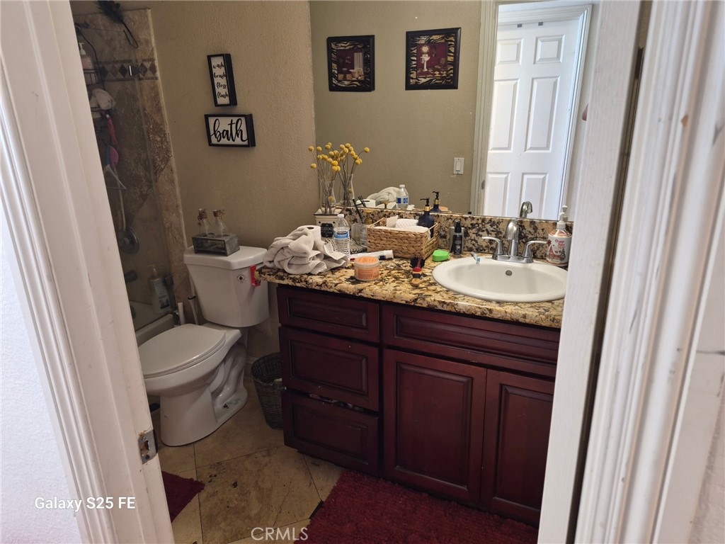 2282 North Smoketree Avenue Rialto, CA 92377 - Photo 14 of 15 a bathroom with a granite countertop toilet sink and mirror