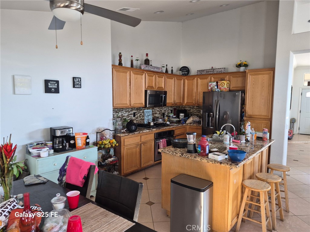 2282 North Smoketree Avenue Rialto, CA 92377 - Photo 2 of 15 a kitchen with stainless steel appliances kitchen island granite countertop a sink and cabinets