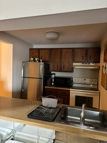 a kitchen with a refrigerator and a stove top oven
