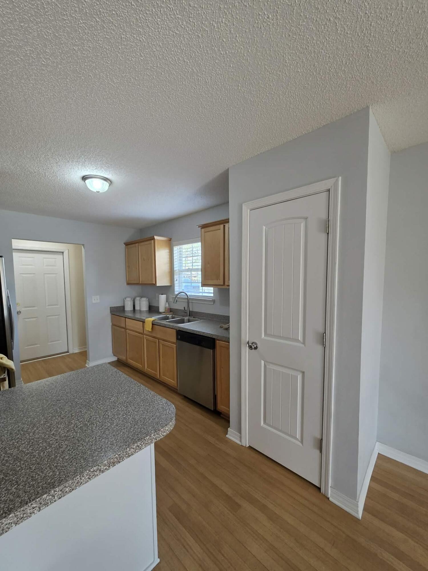 8347 Tavira Street Navarre, FL 32566 - Photo 15 of 49 a kitchen with granite countertop a sink cabinets and wooden floor