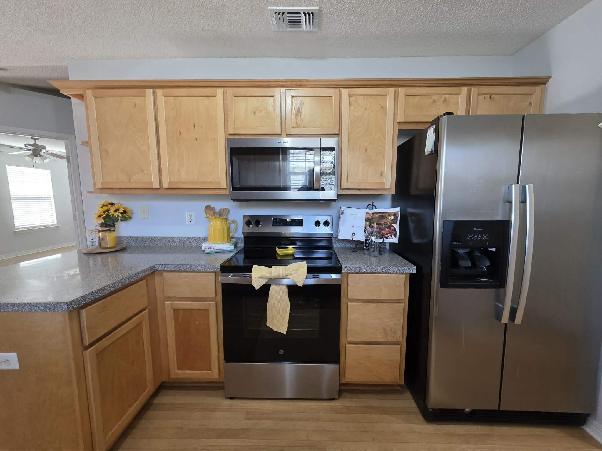 8347 Tavira Street Navarre, FL 32566 - Photo 17 of 49 a kitchen with a stove refrigerator and microwave