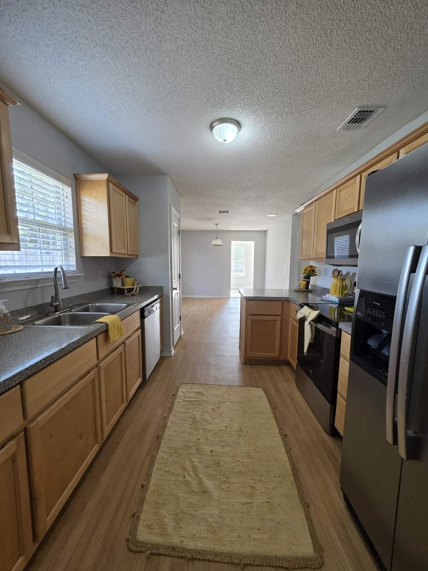 8347 Tavira Street Navarre, FL 32566 - Photo 20 of 49 a large kitchen with stainless steel appliances granite countertop a stove a sink dishwasher and a refrigerator
