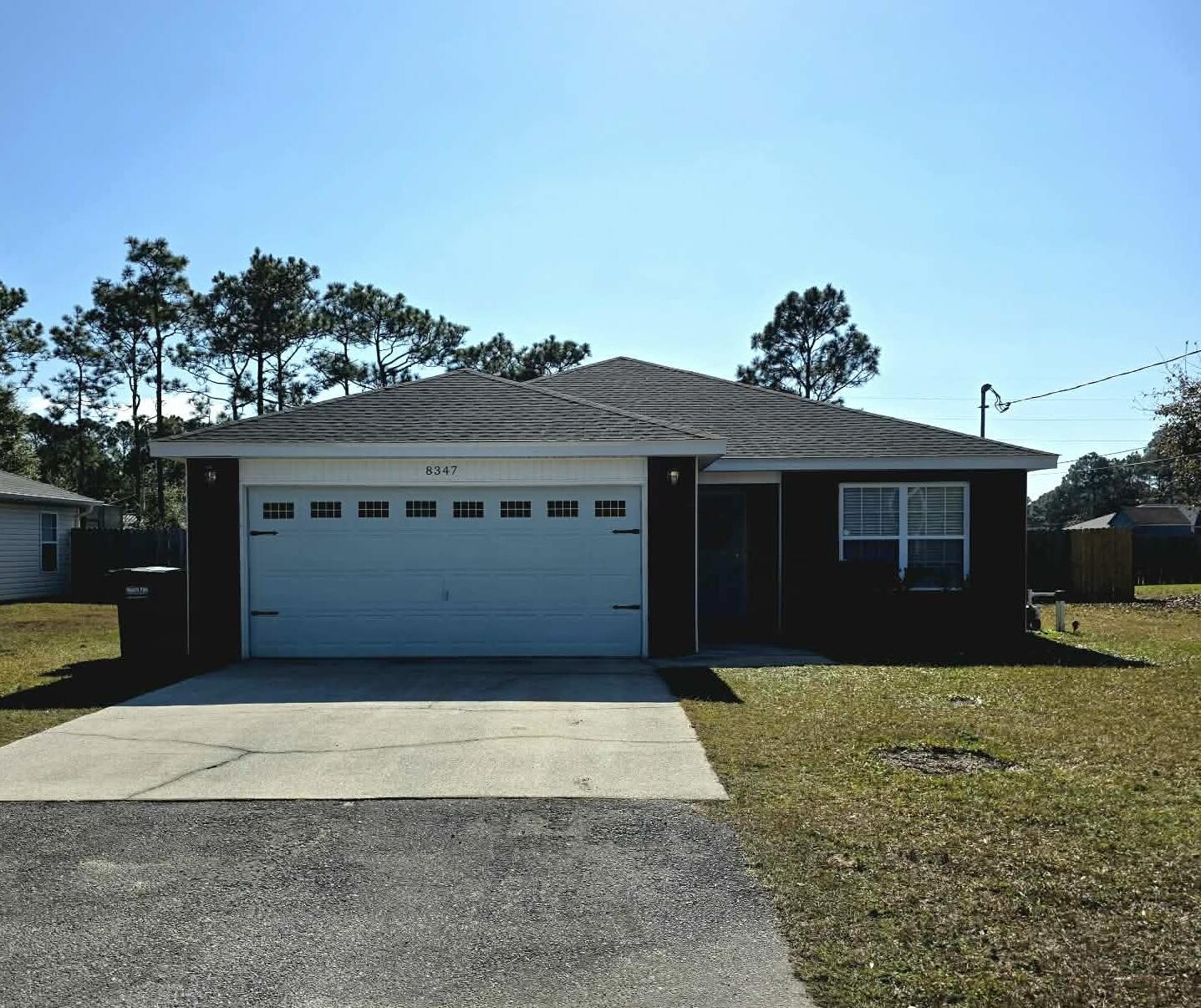 8347 Tavira Street Navarre, FL 32566 - Photo 49 of 49 a front view of a house with a yard and garage
