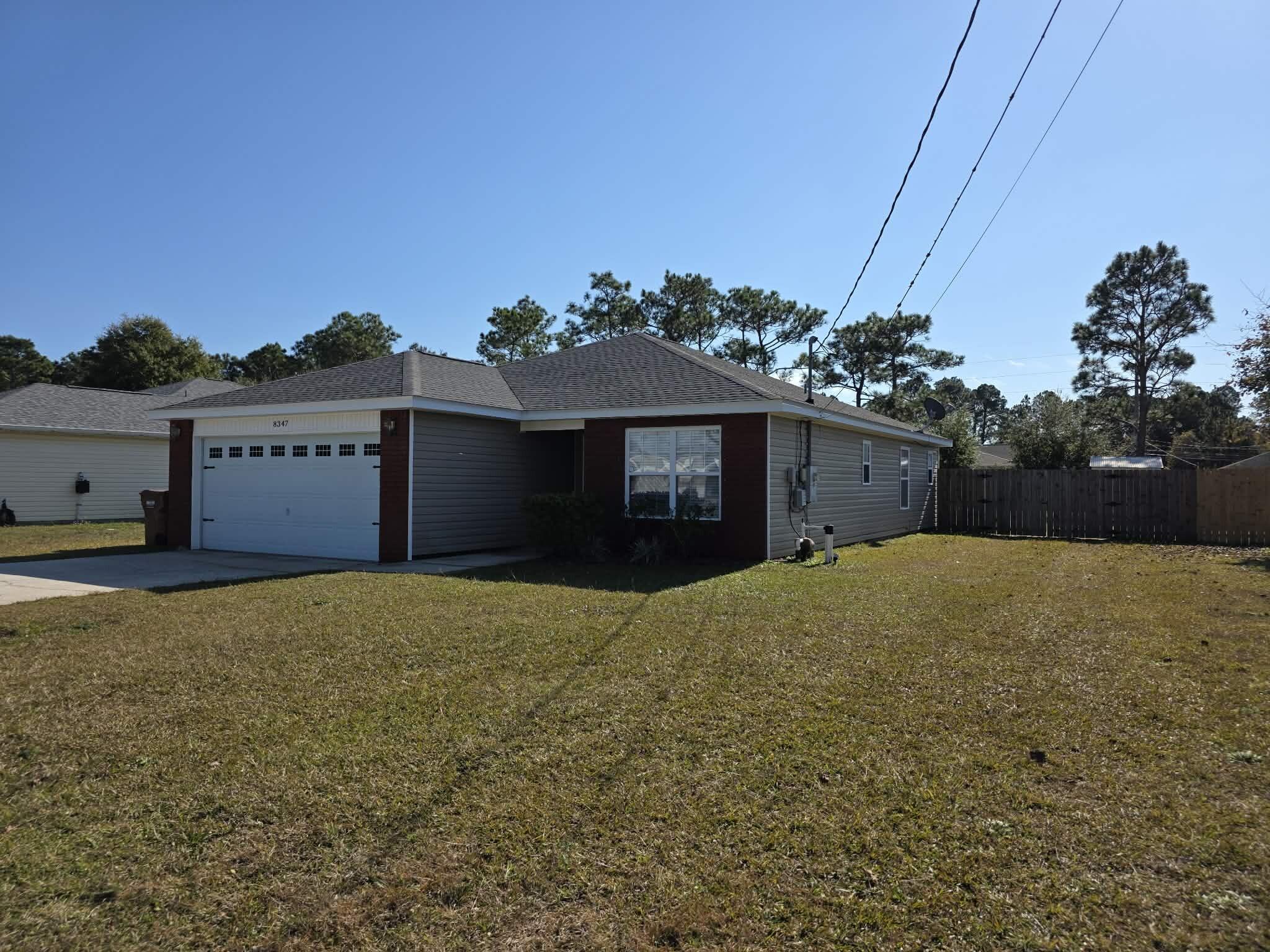 8347 Tavira Street Navarre, FL 32566 - Photo 5 of 49 a front view of a house with a yard and garage