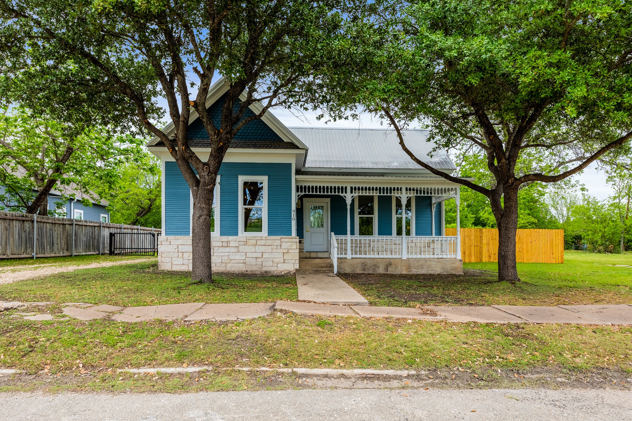 a view of a house with a yard and large tree