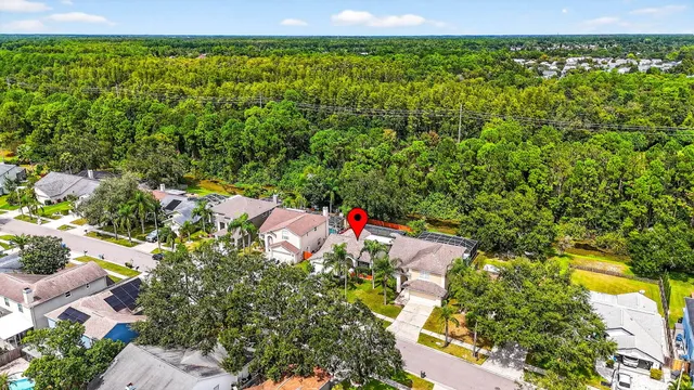 an aerial view of residential houses with outdoor space and trees