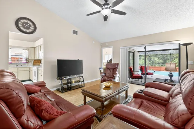 a living room with furniture a large window and a flat screen tv