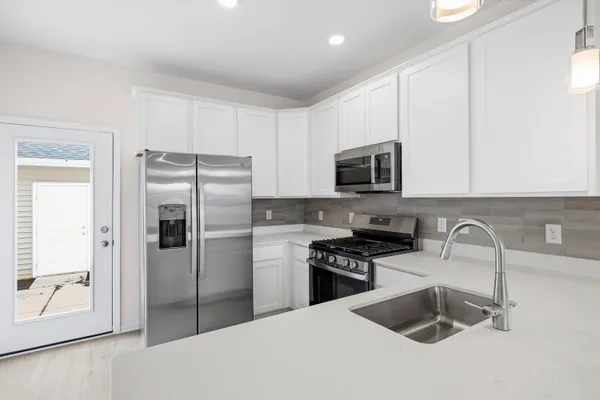 a kitchen with stainless steel appliances granite countertop a refrigerator stove and sink