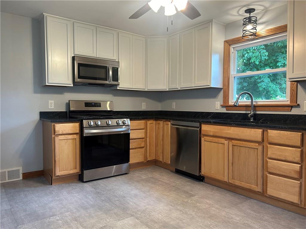 1023 Bonniebrook Road Butler, PA 16002 - Photo 7 of 40 a kitchen with granite countertop a stove a sink and a microwave