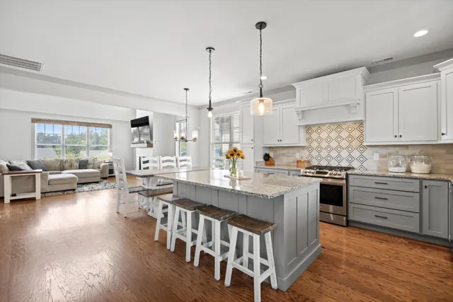 a large white kitchen with lots of counter space a dining table and chairs
