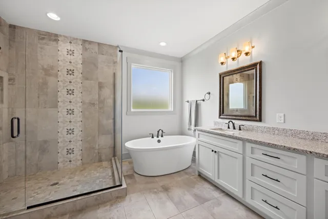 a spacious bathroom with a double vanity sink mirror and bathtub
