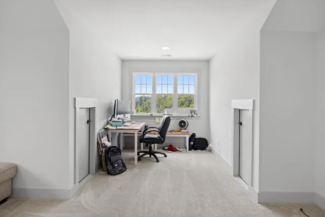 a view of a workspace with furniture and a window