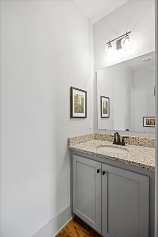a bathroom with a granite countertop sink and a mirror