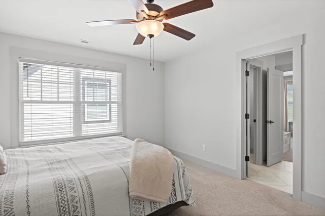 a bedroom with a bed and a chandelier fan