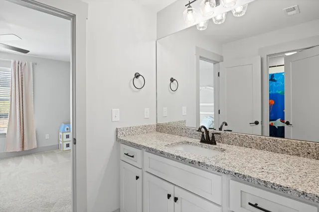 a bathroom with a granite countertop double vanity sink and a mirror