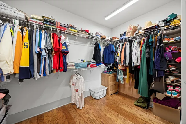 a view of walk in closet with clothes and shoes