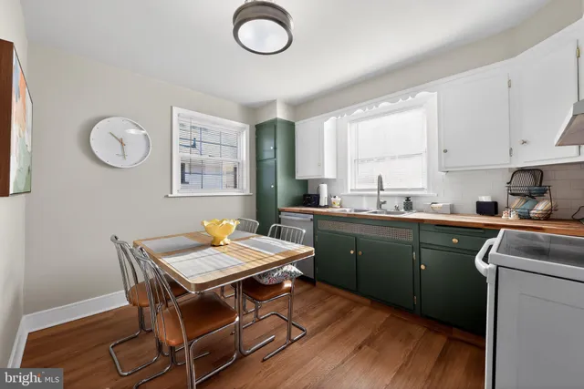 a kitchen with a dining table chairs and refrigerator