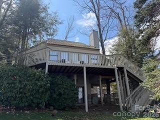 a view of house with large trees and wooden fence