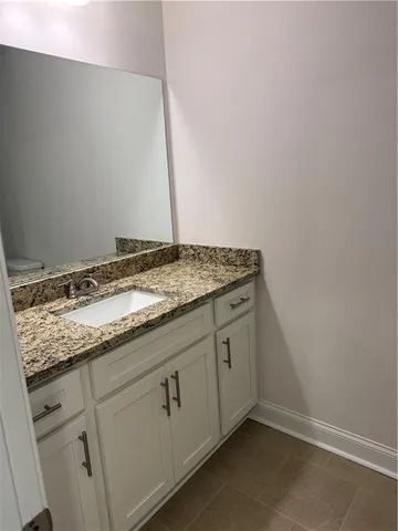 a bathroom with a granite countertop sink and vanity