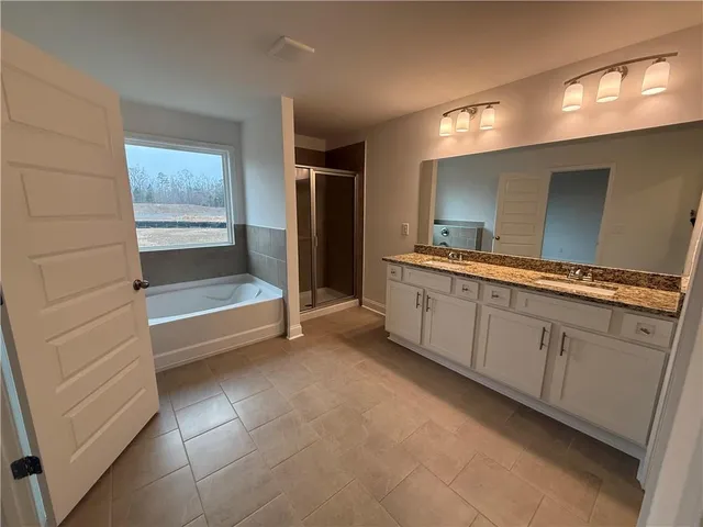 a large en suite bathroom with a sink and a large mirror