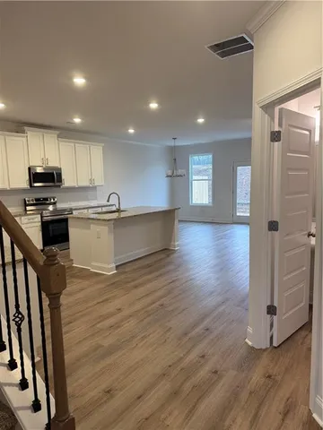 a kitchen with stainless steel appliances granite countertop a sink stove and wooden floor