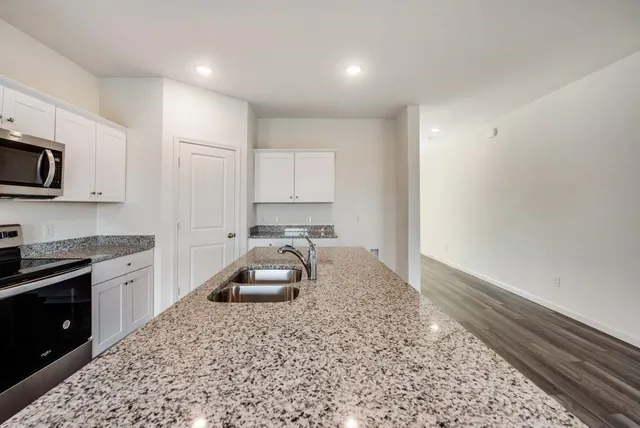 a kitchen with a sink stove and microwave