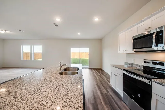 a kitchen with stainless steel appliances a stove sink microwave and cabinets