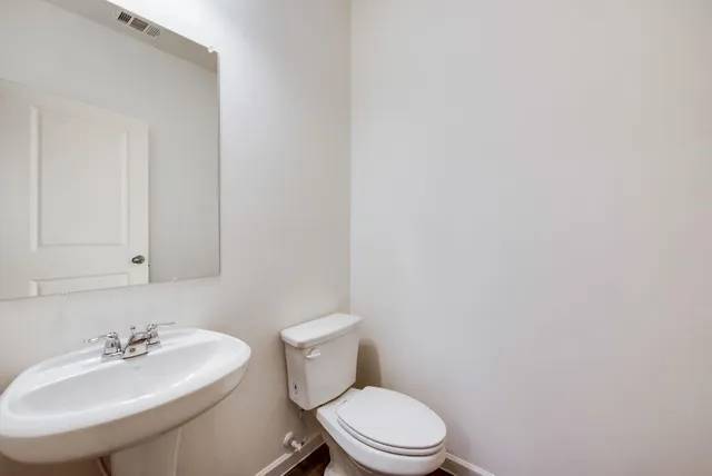 a bathroom with a sink a toilet and mirror