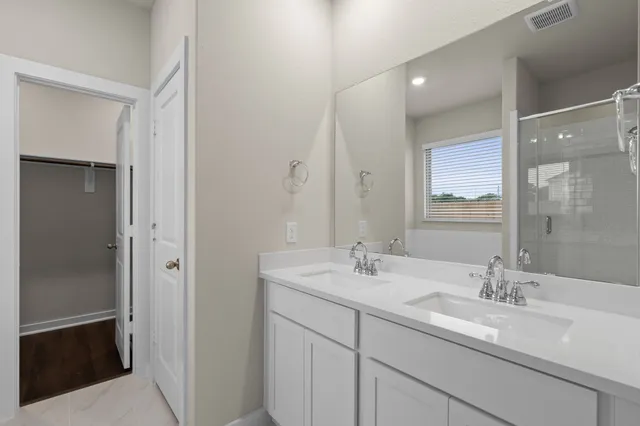 a bathroom with a sink double vanity and a mirror