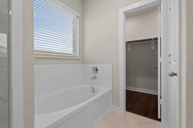 a bathroom with a bathtub and a window