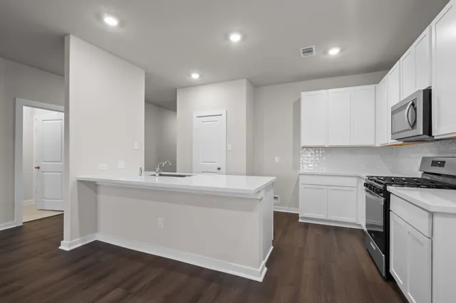 a kitchen with stainless steel appliances granite countertop a sink stove and cabinets