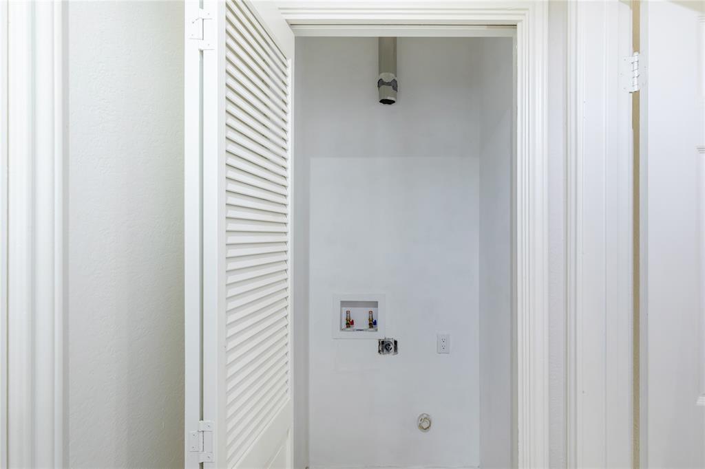 12680 Hillcrest Road, Unit 4101 Dallas, TX 75230 - Photo 23 of 37 Dedicated laundry area featuring a louvered bifold door, white painted walls, and utility hookups