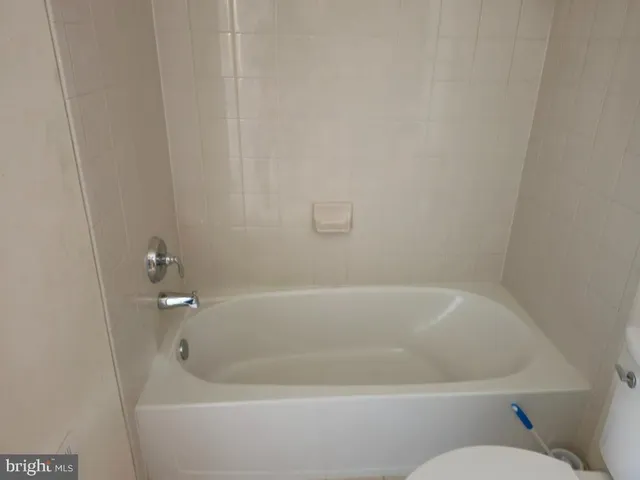 a white bath tub sitting next to a white toilet