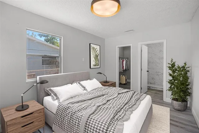 a bedroom with a bed and a potted plant