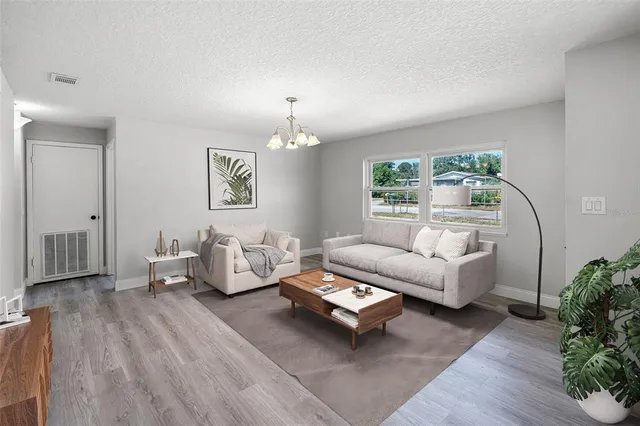 a living room with furniture and a chandelier