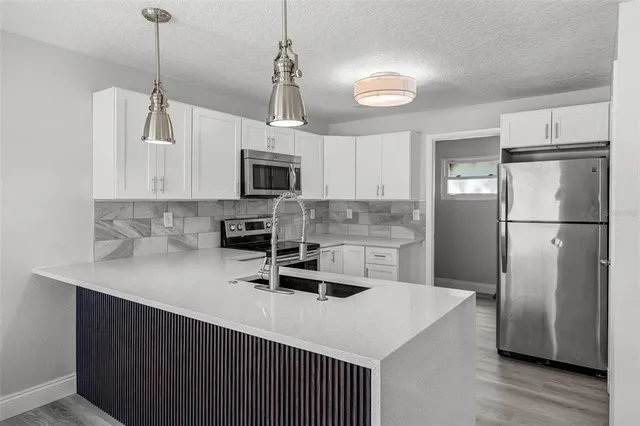 a kitchen with kitchen island a sink appliances a counter space and cabinets