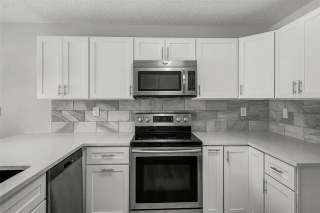 a kitchen with cabinets stainless steel appliances and a sink