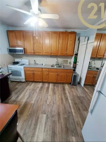 a large kitchen with stainless steel appliances wooden floors wooden cabinets a dining table and chairs