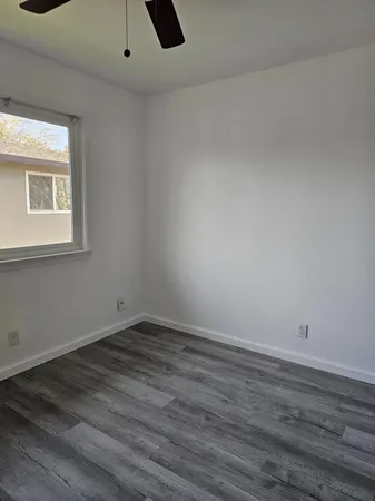 a view of a small space with wooden floor and a window