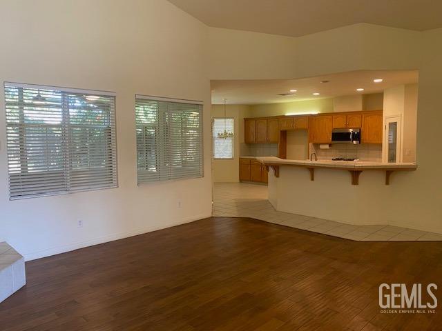 Undisclosed Address Bakersfield, CA 93312 - Photo 3 of 19 a view of a kitchen with kitchen island a sink wooden floor and a large window